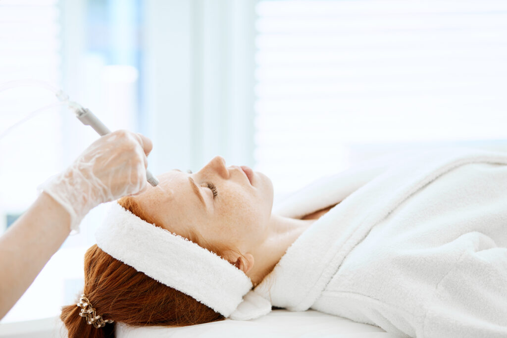 Woman getting face peeling procedure in beauty centre. Facial gas liquid peeling